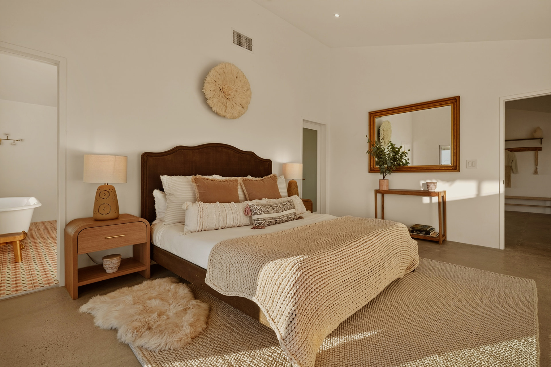Primary bedroom with vintage mirror and reading desk