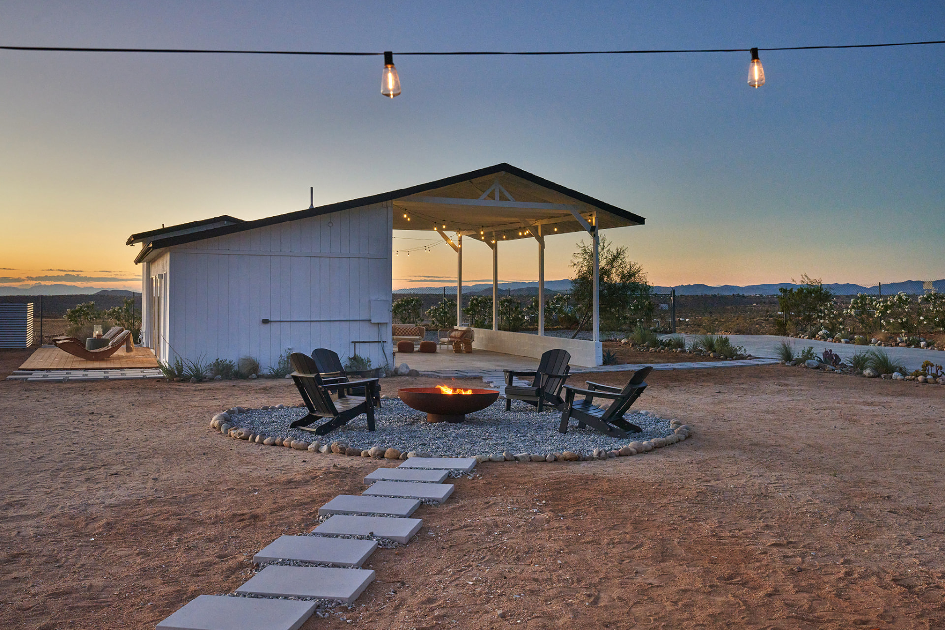 Firepit circle with Adirondack chairs and stepping stones at dusk
