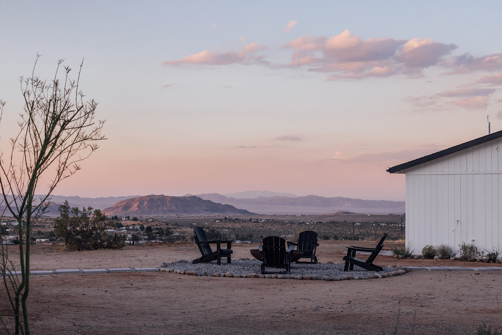 Firepit chairs beneath a pastel sunset overlooking the valley