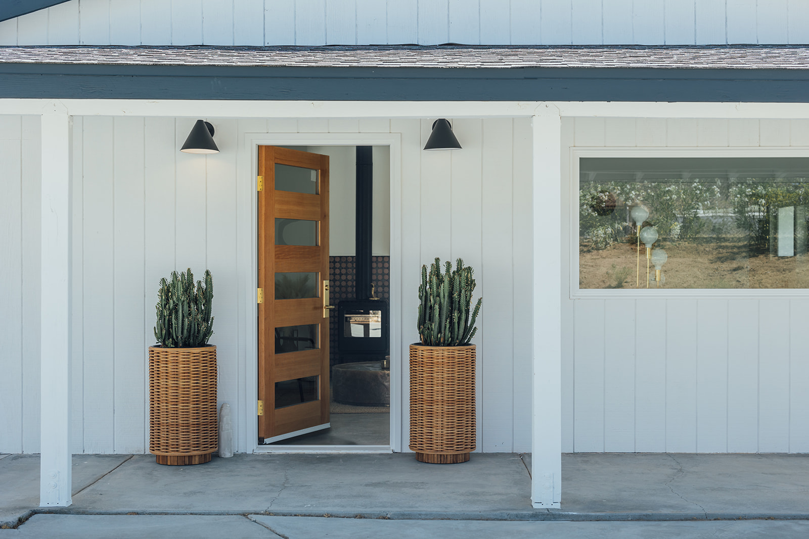 Front entry with wood door and cactus planters