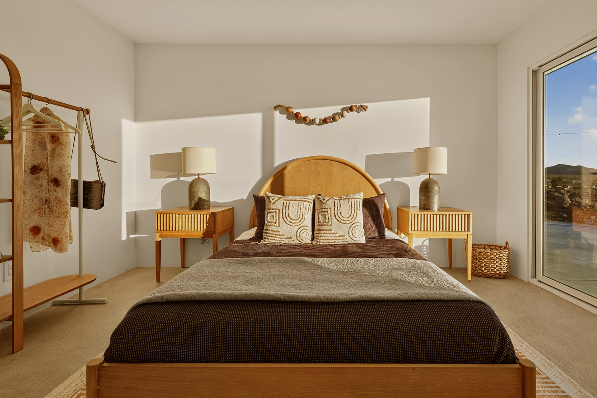 Bedroom with wooden bed, wardrobe rack and pool view