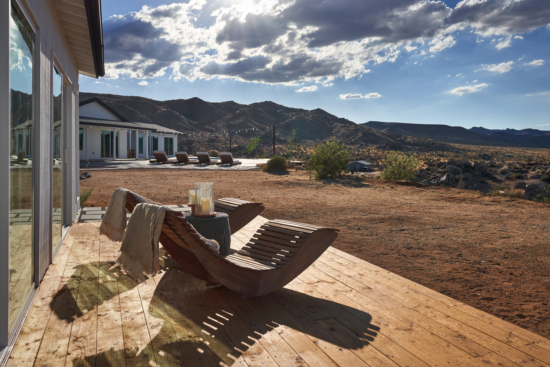 Wooden deck with sculptural lounge chairs overlooking desert mountains