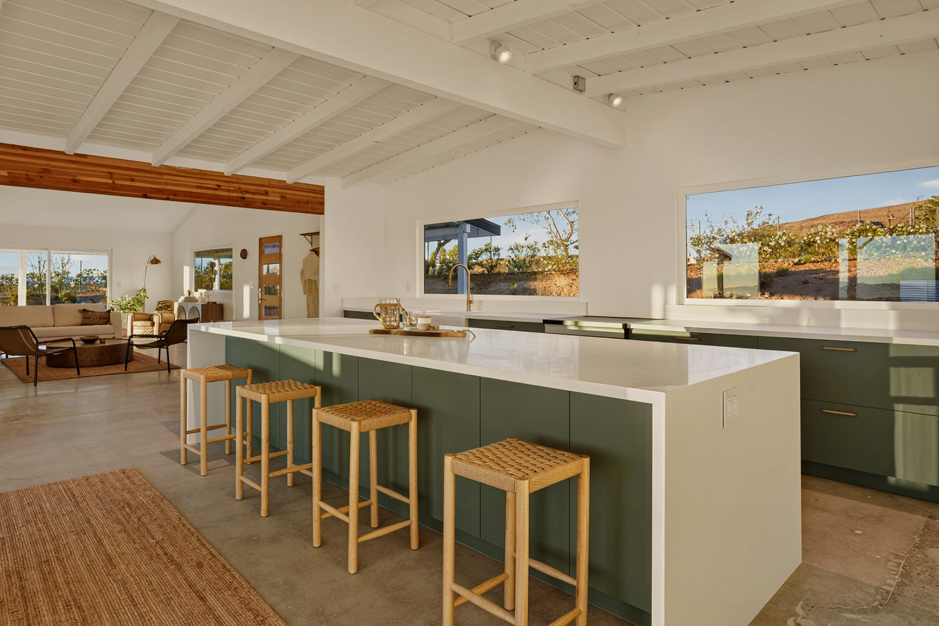 Green kitchen island with woven stools and valley views